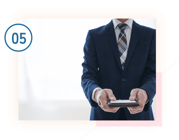 名刺を差し出すスーツ姿の男性
